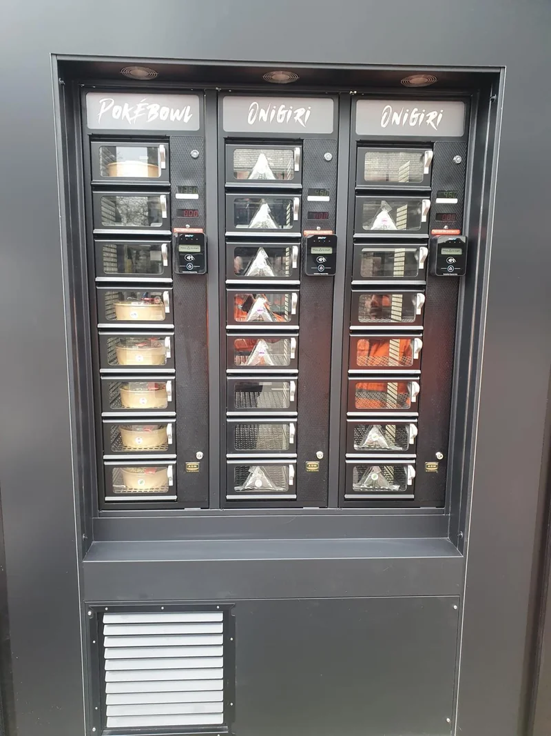 Zwarte ADM-automaten met gepersonaliseerde tekstplaten Pokébowl en Onigiri in witte lettering