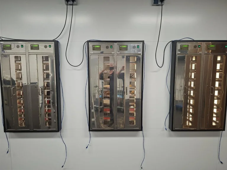 De beheerderszijde van de ADM-snackmuur met vuldeuren en bedieningspanelen boven de automaten