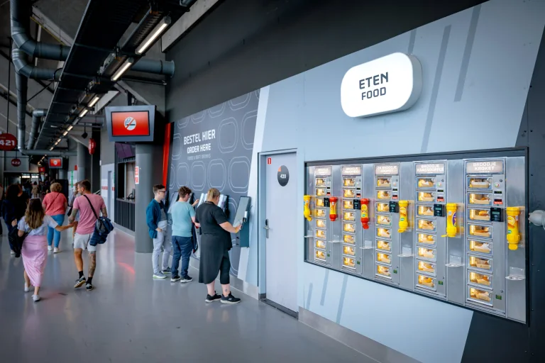 Supporters bij een ingebouwde snackmuur op de omloop van de Johan Cruijff ArenA