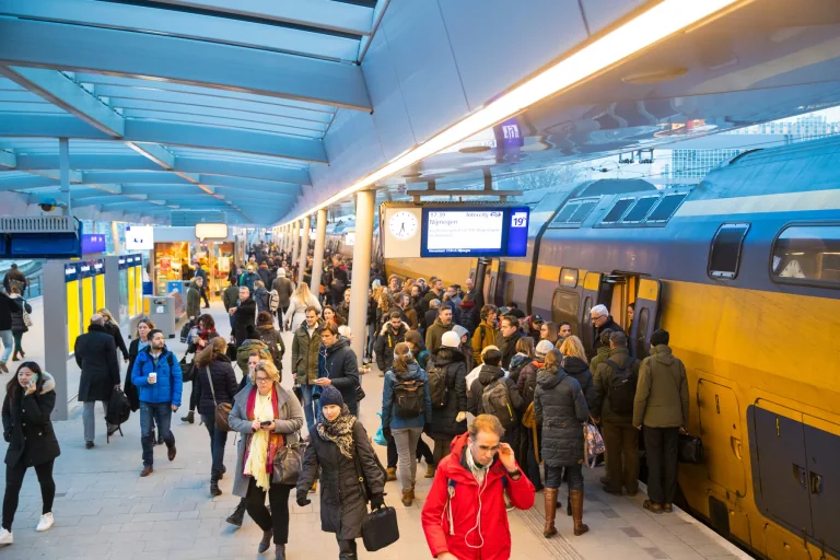 Reizigers op een druk perron naast een NS-intercity